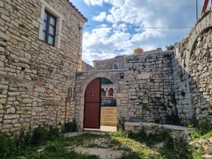 an entrance to a stone building with a wooden door at Villa Olive Old Qeparo in Qeparo +58 photos