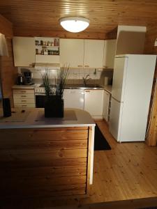 a kitchen with white appliances and a white refrigerator at Talvitahko 3 in Nilsiä