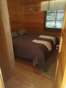 a bedroom with a bed in a wooden room at Talvitahko 3 in Nilsiä