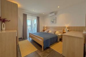 a bedroom with a bed with blue sheets and a window at Dorijini Dvori in Baška Voda