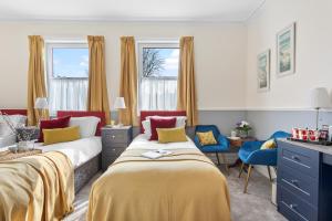 a bedroom with two beds and a blue chair at The Westgate in Torquay