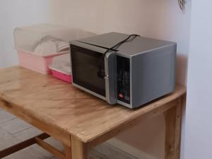 a microwave sitting on top of a wooden table at Padang Besar In front of Border Private room & Hostel in Sathani Padang Besa