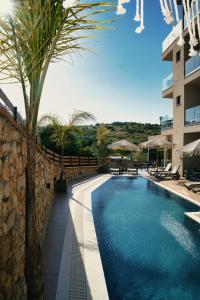 a swimming pool with a palm tree next to a building at Diol Hotel Ksamil in Ksamil