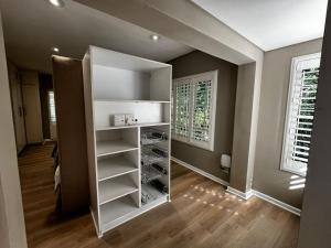 a room with a white book shelf in a room at Athlone Lodge in Pietermaritzburg