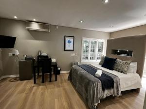 a bedroom with a bed and a desk and a bed and a desk at Athlone Lodge in Pietermaritzburg +28 photos