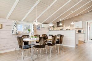 a kitchen and dining room with a table and chairs at 555-Hvide-Sande-Tornbjerrevej-32 in Havrvig +36 photos