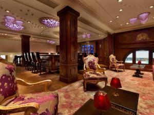 a large room with a bar with chairs and a table at The Plaza, A Fairmont Hotel in New York