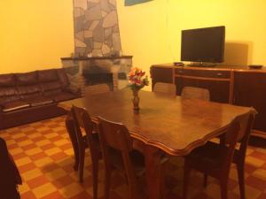 a living room with a wooden table and a television at Casa Cami seña para confirmar reserva in Piriápolis