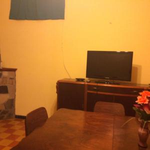 sala de estar con TV en un escritorio de madera en Casa Cami seña para confirmar reserva, en Piriápolis