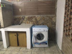una lavatrice e un'asciugatrice, posti accanto a un bancone di Casa Cami seña para confirmar reserva a Piriápolis