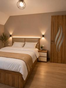 a bedroom with a large bed and a wooden door at Wonder Hill group in Bakuriani