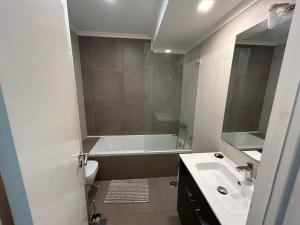 a bathroom with a tub and a sink and a toilet at Sal Guest House in Costa da Caparica +48 photos