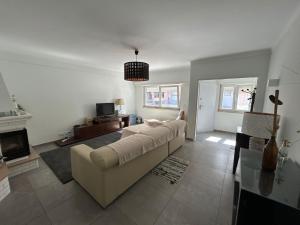 a living room with a couch and a fireplace at Sal Guest House in Costa da Caparica