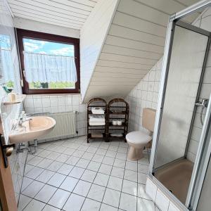 a bathroom with a sink toilet and a window at Winzerhaus St Joseph in Piesport