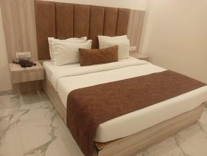 a bedroom with a large bed with white sheets and pillows at Hotel The Best IGI Delhi in Kānpur