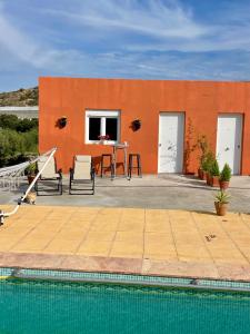 a house with an orange wall and a swimming pool at Cortijo Maya 2 chambres piscine in Alhama de Almería
