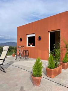 a red building with potted plants in front of it at Cortijo Maya 2 chambres piscine in Alhama de Almería