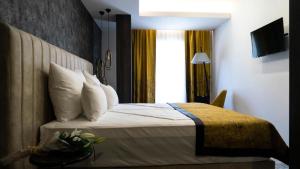 ein Schlafzimmer mit einem Bett mit weißen Kissen und einem Fenster in der Unterkunft Hotel Pasha in Mostar