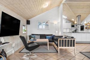 a living room with a couch and a tv at 461-Hvide-Sande-Tingodden-152 in Hvide Sande