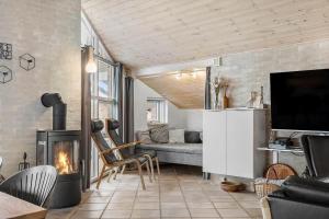 a living room with a fireplace and a couch at 461-Hvide-Sande-Tingodden-152 in Hvide Sande