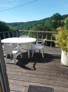 a white table and chairs on a wooden deck at Gîte rustique en Morvan in Brassy +10 photos
