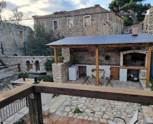 a patio with a stone fireplace in front of a building at Villa Olive Old Qeparo in Qeparo