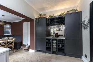 a kitchen with black cabinets and a kitchen with a table at 2BR House By Cozy Quarters Property Management Holiday Lets Sedgefield With Open Field & Countryside Views in Sedgefield