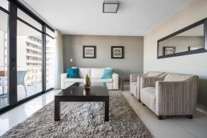a living room with a couch and a coffee table at Aquarius Luxury Suites in Bloubergstrand