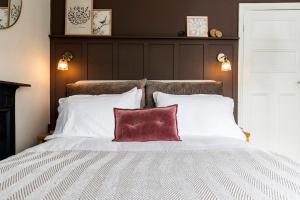 a large bed with a red pillow on it at 2BR House By Cozy Quarters Property Management Holiday Lets Sedgefield With Open Field & Countryside Views in Sedgefield