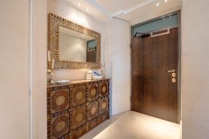a bathroom with a mirror and a wooden door at Damè in Conversano +22 photos
