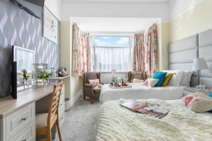 a bedroom with two beds and a desk and a room with a bed at The Westgate in Torquay