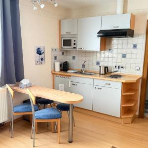 a kitchen with a wooden table and a table and chairs at Winzerhaus St Joseph in Piesport