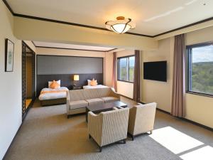 a hotel room with a bed and a couch at Livemax Resort Hakodate Shikabe Onsen in Shikabe