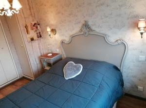 a bedroom with a bed with a heart pillow on it at Gîte Le Chemin du Cap in Plévenon