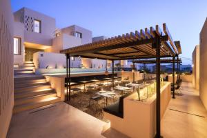 a patio with tables and chairs on a building at Enorme EOS Santorini - Adults Only in Pyrgos