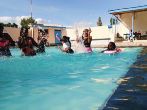 a group of people playing in a swimming pool at Chwele Premier Resort in Bungoma