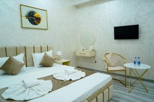 a bedroom with a bed and a table and a tv at Astoria Inn Hotel in Toshkent-Passajir Bekati