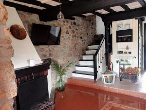 a living room with a staircase and a tv at Flor de Pomar in Corao