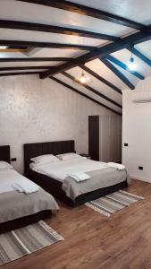 two beds in a room with blue ceilings and wooden floors at Casa YDA in Horezu +161 photos