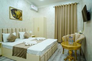 a hotel room with two beds and a table at Astoria Inn Hotel in Toshkent-Passajir Bekati