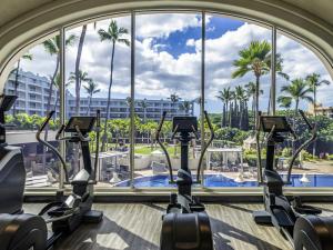 a gym with cardio machines in front of a large window at Fairmont Kea Lani, Maui in Wailea