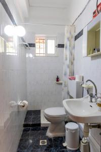 a white bathroom with a toilet and a sink at Apartment's Eleni in Kamena Vourla +21 photos