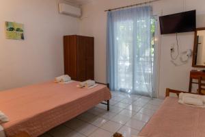 a bedroom with two beds and a window at Apartment's Eleni in Kamena Vourla