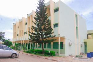a car parked in front of a building with a tree at Hotel JB&G in Cotonou
