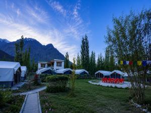 a group of tents in a field with mountains at Hotel Nubra Delight and Camps in Hundar