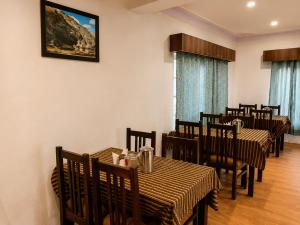 a dining room with tables and chairs and a painting on the wall at Hotel Nubra Delight and Camps in Hundar +11 photos