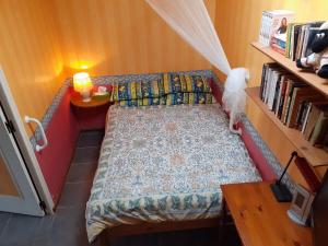 a small bedroom with a bed and a book shelf at Brise Fraîche de la Montagne-Piscine et Jacuzzi-Appartement Cottage au rez-de-chaussée in Le Poujol-sur-Orb