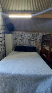 a bedroom with a bed with a white bedspread at Chale mundo da Lua 2 in Piedade