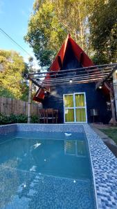a house with a swimming pool in front of a house at Chale mundo da Lua 2 in Piedade