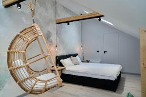 a bedroom with a bed and a hanging chair at BlackBird Hub in Arad